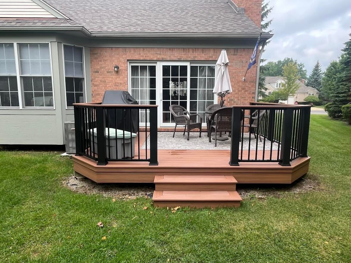 Finished composite deck with black aluminum railing on a brick ranch home, Northville MI