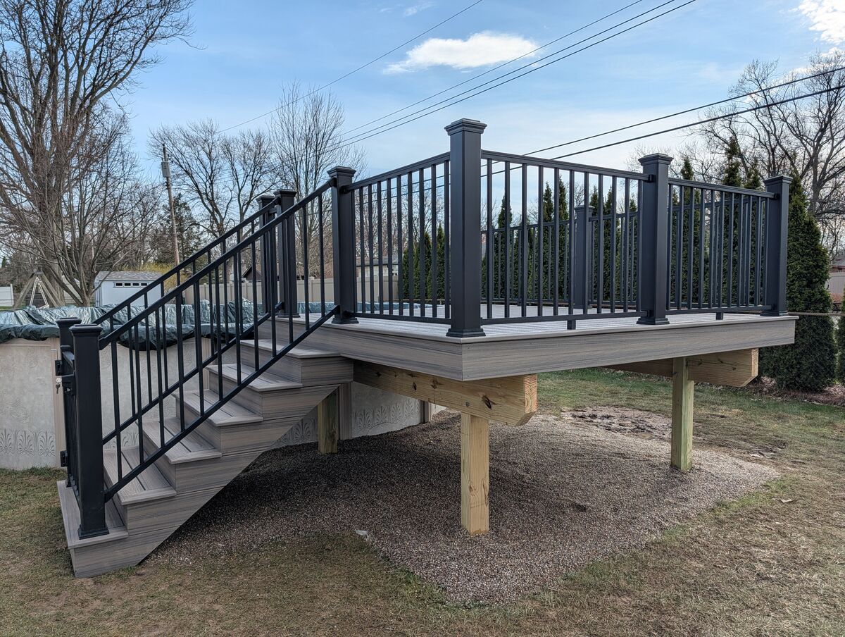 Elevated composite deck with stairs and black aluminum railing, South Lyon MI