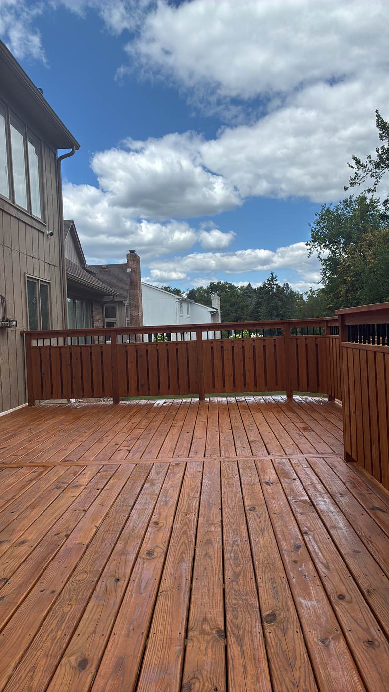 Close-up of a newly stained deck against vinyl siding in Green Oak Township, MI
