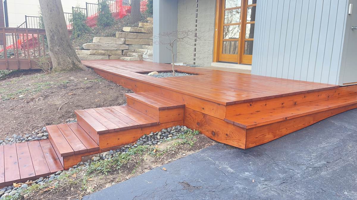 Deck with steps down to a stone patio near French doors in Lapeer, MI