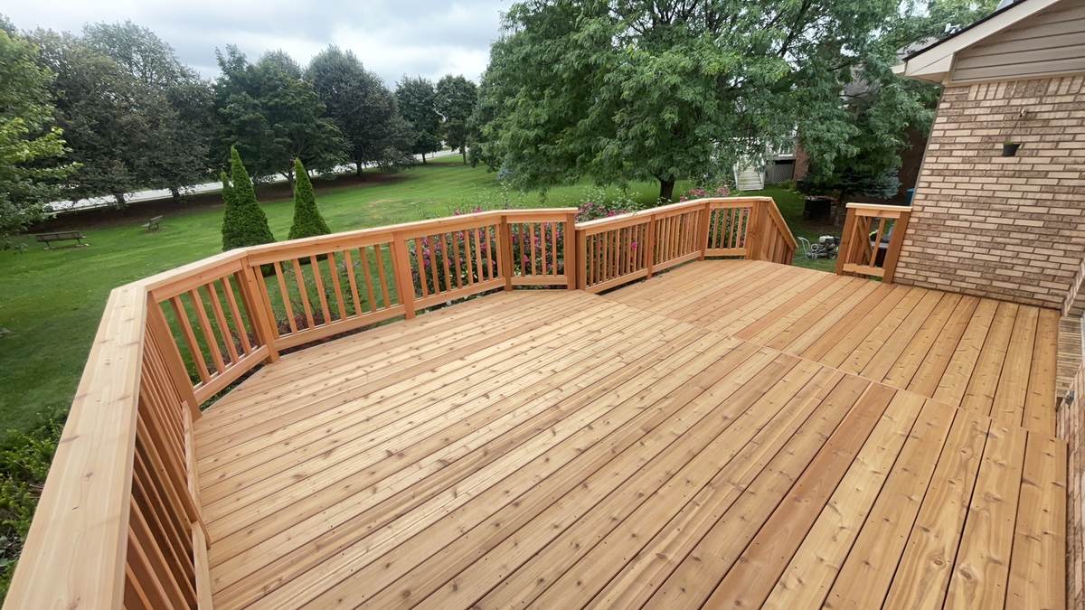 Wide curved deck with railings overlooking an open lawn in Monroe, MI