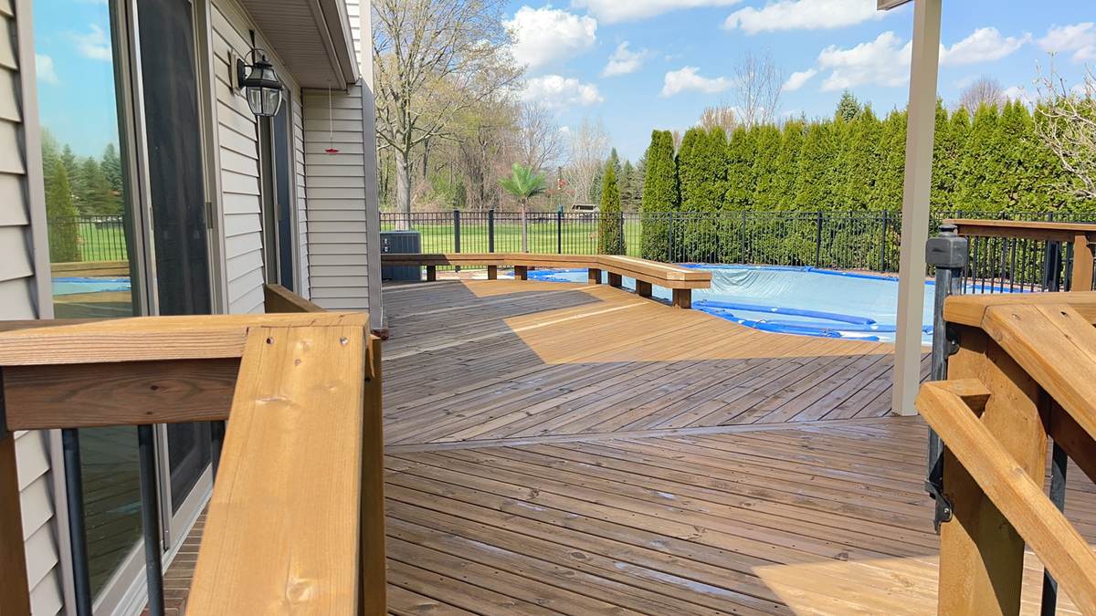 Deck surrounding an in-ground pool with metal fencing in Ortonville, MI