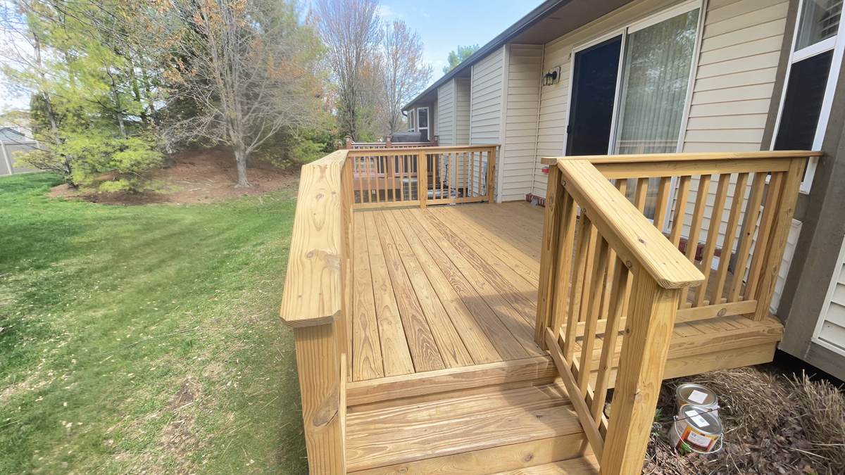 Natural wood deck with steps down to the backyard lawn in Warren, MI