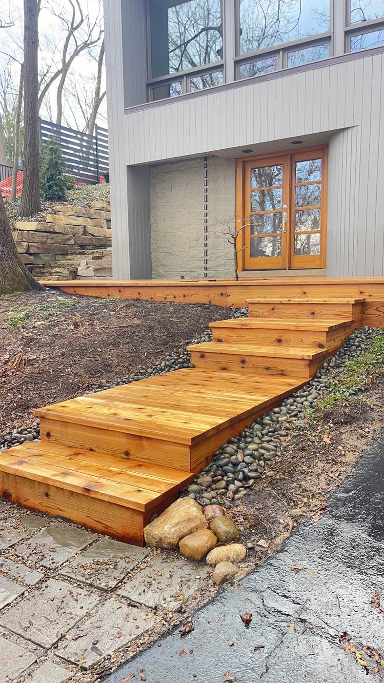 Custom fence panel built into a hillside retaining wall in Brighton Township, MI