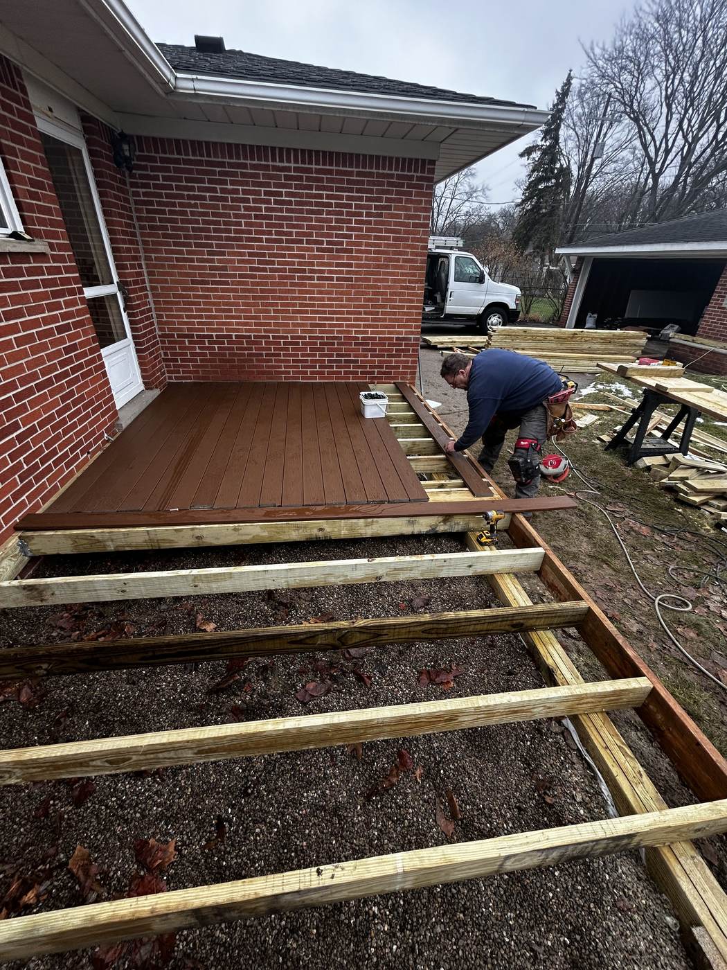 Deck framing and joist construction underway on a brick patio in Woodhaven, MI