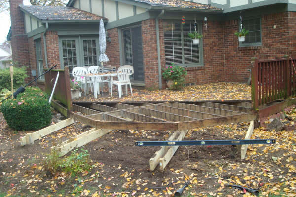 Old rotted deck being torn out, exposing bare framing, Livonia MI